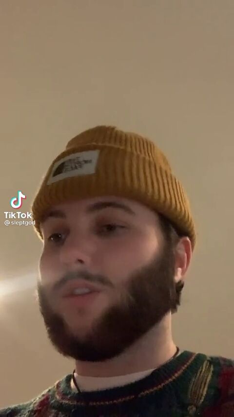 tiktok video of a man with beard and toque speaking to camera from low angle