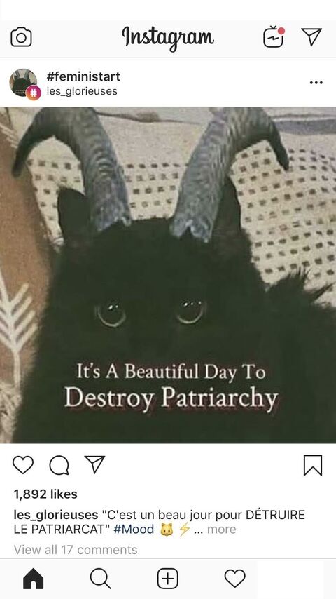 there is a black cat with horns on its head sitting on a couch